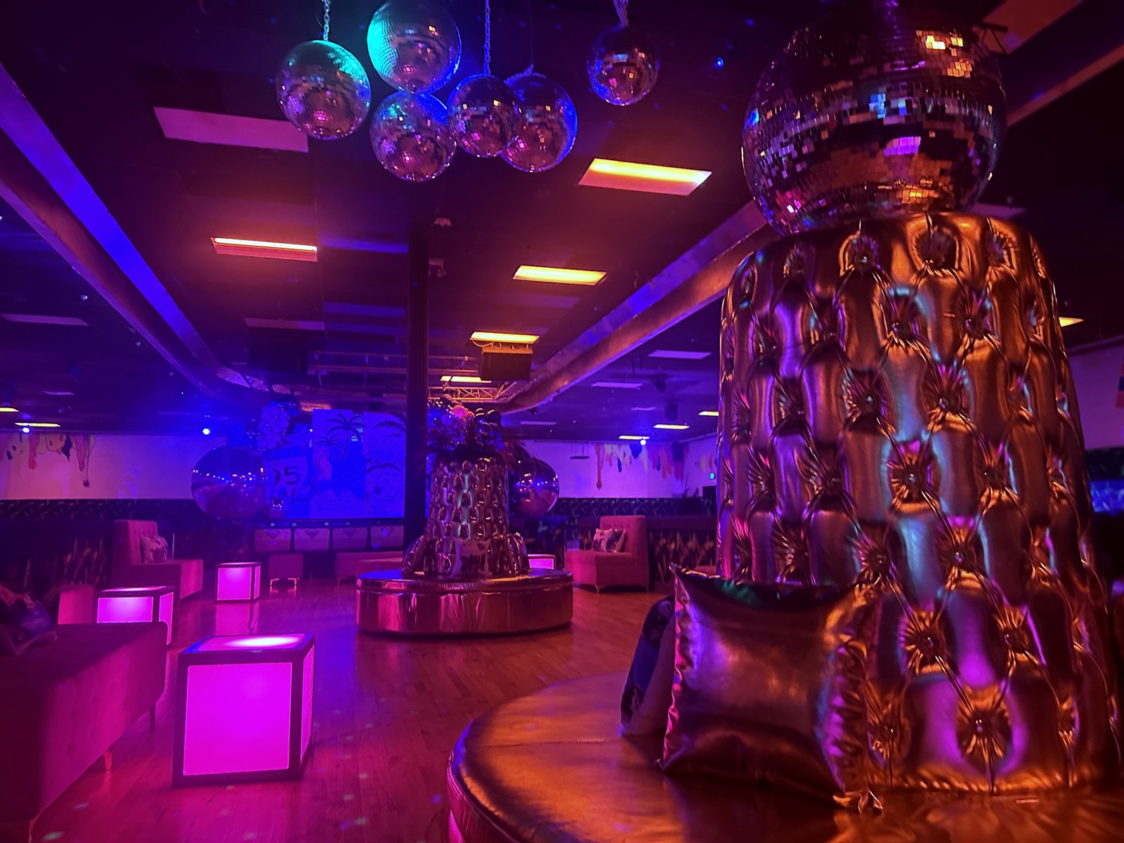 Neon disco-ball lounge and seating area with magenta and cyan lighting