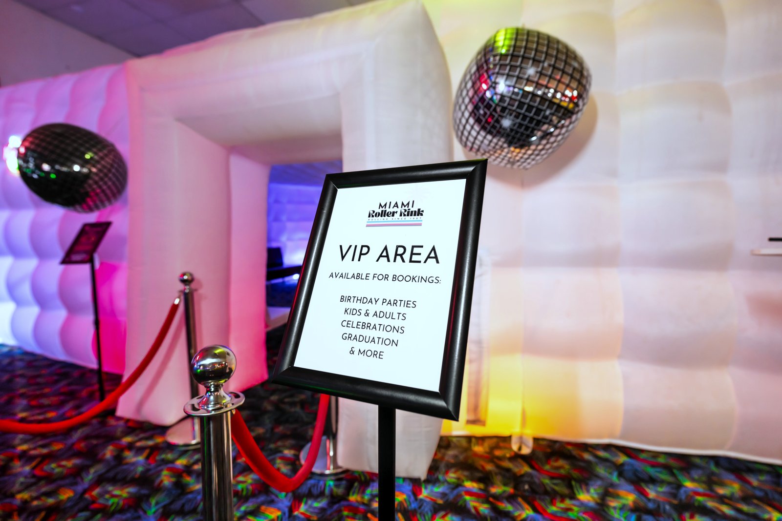 Roped-off VIP area with a disco ball and VIP Area sign